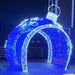 12FT Blue and Cool White Walkthrough Ornament decorated with snowflakes in a yard setting