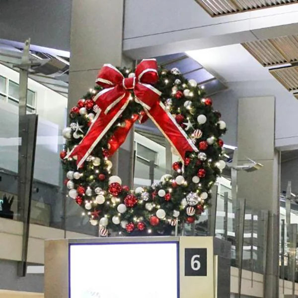 Red, white, and silver pre-decorated Christmas wreath illuminated with warm white lights