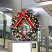 Red, white, and silver pre-decorated Christmas wreath illuminated with warm white lights